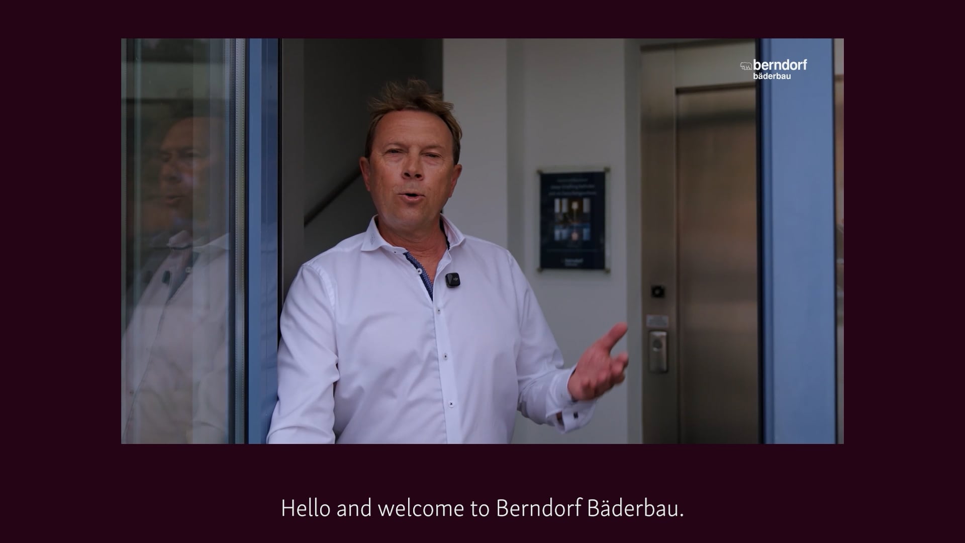 Opening frame of the Berndorf Bäderbau image film: managing director welcoming visitors at the entrance